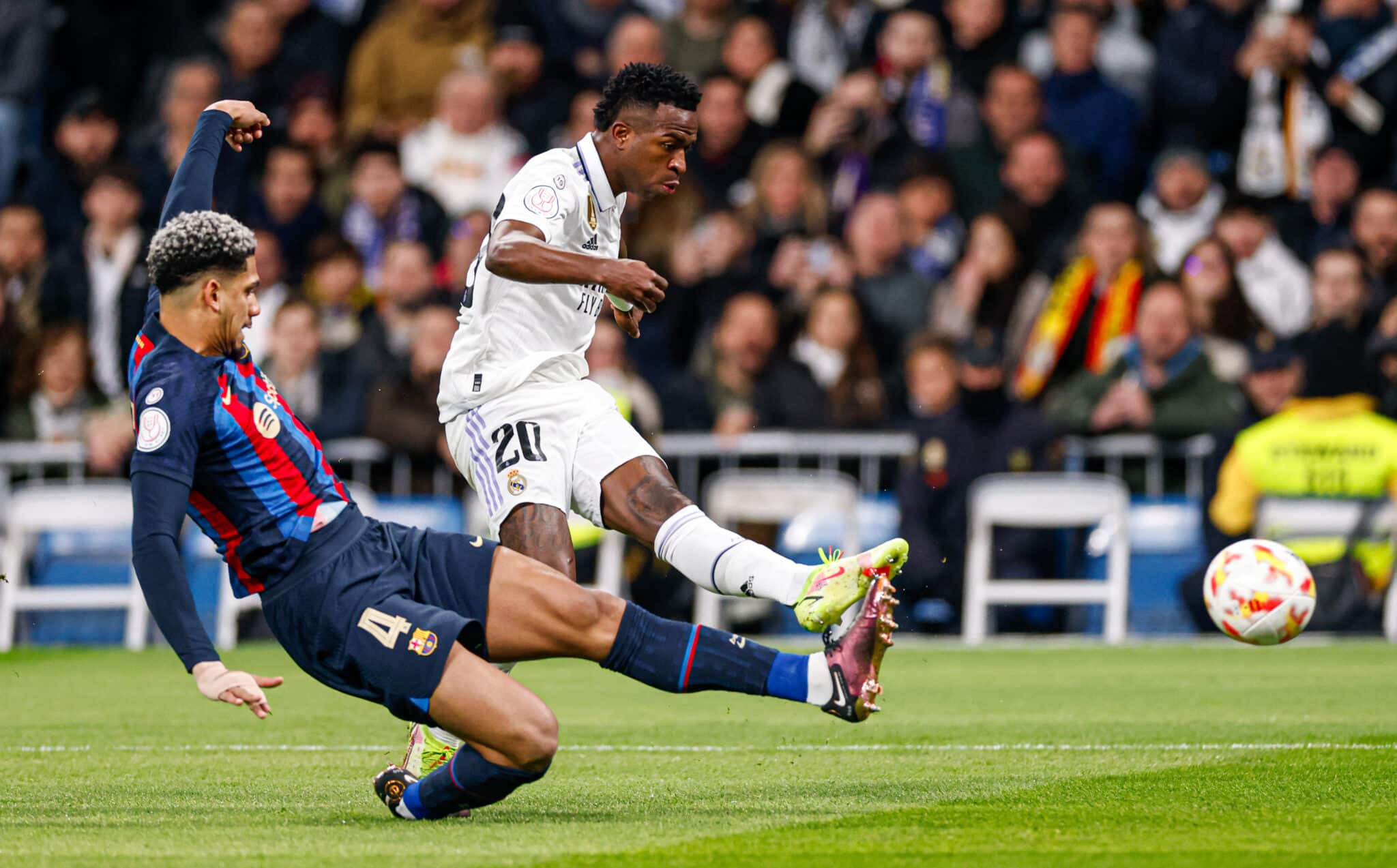 Vinicius Junior player of Real Madrid kicks the ball as Ronald Araujo of Barcelona slides during the Copa Del Rey Semi Final