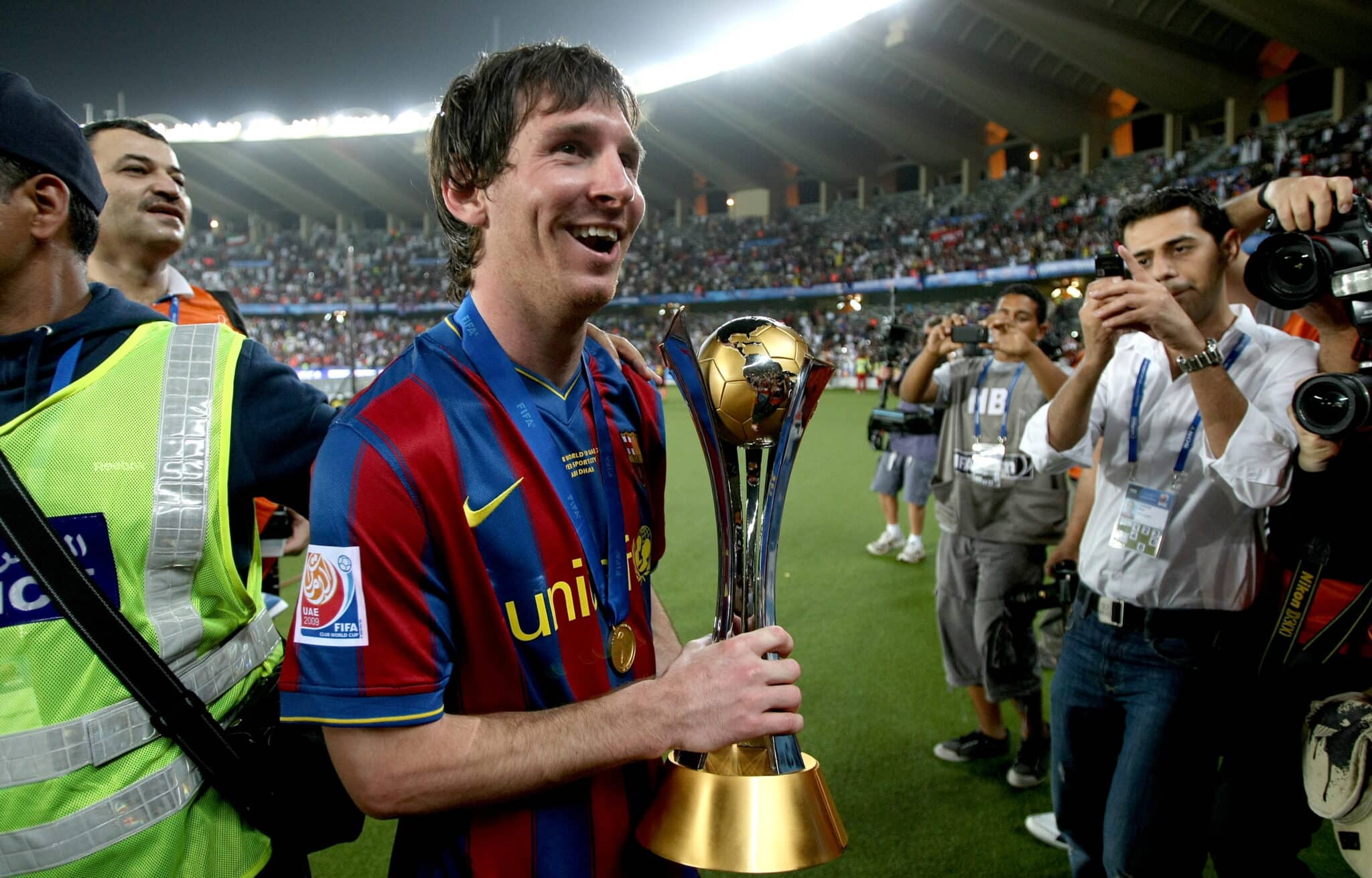 Barcelona's Lionel Messi holds the 2009 FIFA Club World Cup trophy as he celebrates the Spanish club's victory at Zayed Sports City Stadium in Abu Dhabi on December 19, 2009. Barcelona beat Argentina's Estudiantes de La Plata 2-1 in the final football match. AFP PHOTO/MARWAN NAAMANI