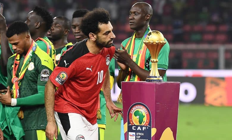 Egypt's forward Mohamed Salah walks past the trophy after losing the Africa Cup of Nations (AFCON) 2021 final