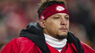 KANSAS CITY, MISSOURI - DECEMBER 07: Patrick Mahomes #15 of the Kansas City Chiefs looks on from the sideline during the national anthem prior to an NFL football game against the Houston Texans at GEHA Field at Arrowhead Stadium on December 7, 2025 in Kansas City, Missouri.