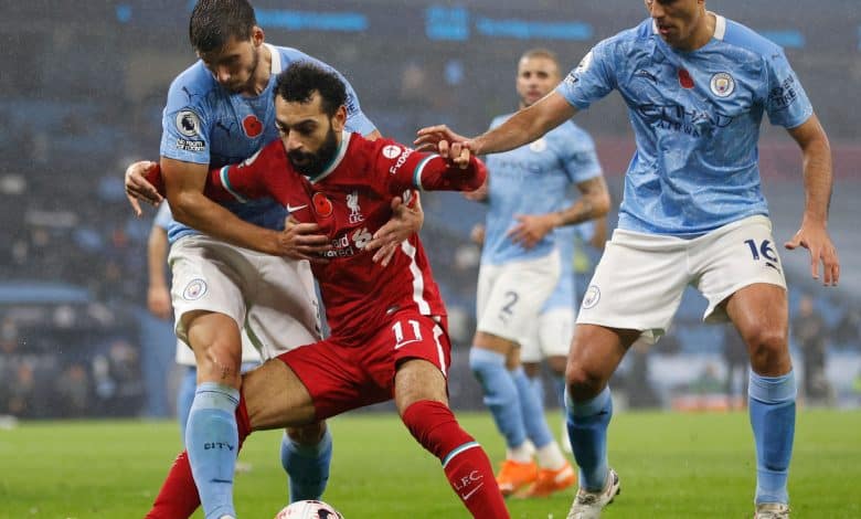 Liverpool's Egyptian midfielder Mohamed Salah (C) battles with Manchester City's Portuguese defender Ruben Dias (L) and Manchester City's Spanish midfielder Rodri (R) during the English Premier League football match between Manchester City and Liverpool at the Etihad Stadium in Manchester, north west England, on November 8, 2020. (Photo by Clive Brunskill / POOL / AFP) / RESTRICTED TO EDITORIAL USE. No use with unauthorized audio, video, data, fixture lists, club/league logos or 'live' services. Online in-match use limited to 120 images. An additional 40 images may be used in extra time. No video emulation. Social media in-match use limited to 120 images. An additional 40 images may be used in extra time. No use in betting publications, games or single club/league/player publications. / (
